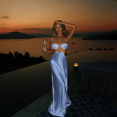Women's blue satin low cut out maxi dress with halter neck and sheath silhouette.